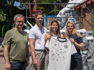 Announcement of UEFA Women's EURO squad Ann-Kathrin Mack and Nia Künzer hold a signed national team jersey together. Next to them are Christian Wück and Nicolas Mack.