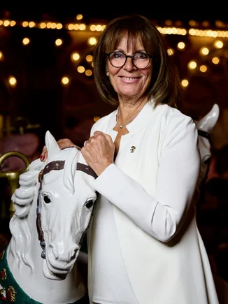 Marianne Mack on the Eden Palladium carousel Marianne Mack stands next to a wooden horse from the historic Eden Palladium carousel.