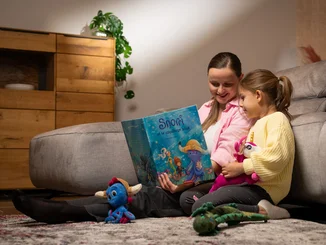 Zwei Kinder schauen sich gemeinsam das Kinderbuch von Snorri an. 