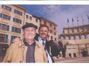 Franz and Roland Mack in front of the façade of hotel ‘Colosseo’ under construction, with the Colosseum arch. Franz and Roland Mack in the courtyard of hotel 'Colosseo', which is currently under construction, on a sunny day.