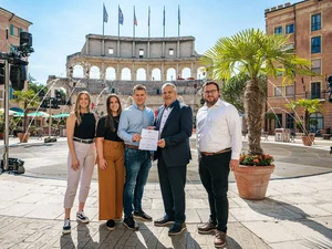 TOP Training Company Cynthia Ziegler, Annabelle Galm, Frederik Mack, Peter Erhardt and Jan-Luca Bachmann in front of hotel 'Colosseo' with the ‘TOP Training Company’ certification.