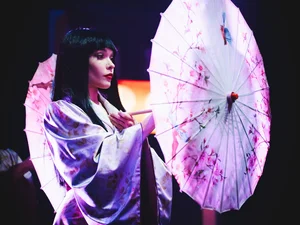 Performer in the Europa-Park Dinner-Show A dancer from the Europa-Park Dinner-Show wearing a striking costume and carrying an umbrella.