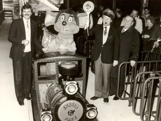 Alpenexpress-Eröffnung mit Roland Mack, Franz Mack und Euromaus im Zug. Eröffnung des Alpenexpress mit Zug in der Mitte, Roland Mack links, Franz Mack rechts und Gästen im Stationsgebäude.