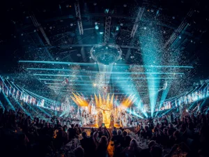 Europa-Park 50th anniversary gala – live stream Many artists and performers can be seen on stage at the Europa-Park Arena. Confetti floats through the air.