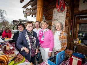 Mauritia Mack with a group of women behind a cake stand.