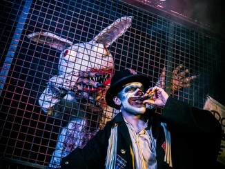 Darsteller in Grims Funhouse Darsteller mit Zigarre und Darsteller im Wakala Kostüm in Grims Funhouse, einer Scare Attraction von Traumatica – Festival of Fear.