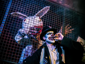 Darsteller in Grims Funhouse Darsteller mit Zigarre und Darsteller im Wakala Kostüm in Grims Funhouse, einer Scare Attraction von Traumatica – Festival of Fear.