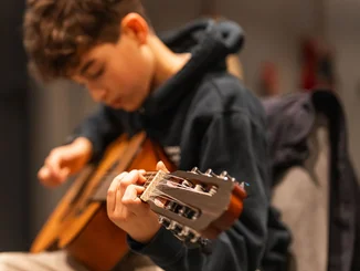 Junge Musiker, große Talente Ein junger Künstler mit einer Gitarre.