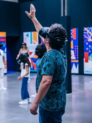 Neue Welten mittels VR erleben Mann mit VR-Headset streckt die Hand aus.