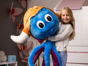 Mädchen hält einen riesigen Plüsch-Snorri in den Armen.