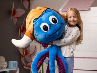 Mädchen hält einen riesigen Plüsch-Snorri in den Armen.