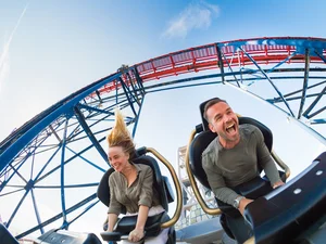 Zwei Personen genießen die Fahrt auf der Achterbahn Dynamite.