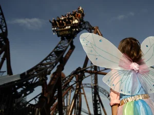 50 years of Europa-Park – image film A little girl dressed up with fairy wings at Europa-Park. She looks up at the rollercoaster Voltron Nevera powered by Rimac.