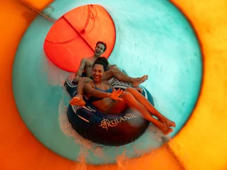 Paar rutscht gemeinsam die rasante Rutsche Två Fall in der Wasserwelt Rulantica. 