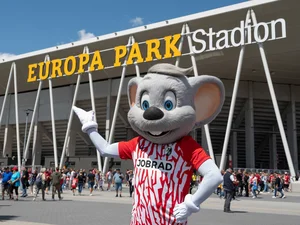 Europa-Park Stadium Ed Euromaus wearing an SC Freiburg jersey in front of the stadium.