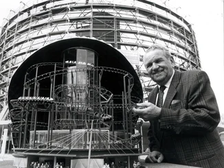 Franz Mack presents a model of Eurosat in front of the construction site. Franz Mack with a model of Eurosat in front of the construction site, showing a cross-section of the attraction.