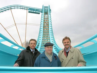 Two generations of the Mack family on the empty Atlantica SuperSplash. Jürgen, Franz and Roland Mack stand on Atlantica SuperSplash in winter between turquoise rails.