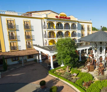 Front view of hotel 'El Andaluz' with Spanish landscaping and décor in the sunshine.