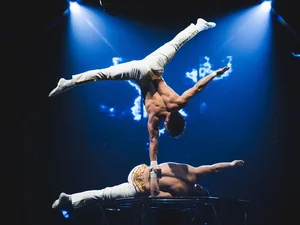 Just 2 Men An acrobat from the Europa-Park Dinner-Show balances on one hand, supported by his partner's hand.