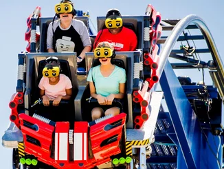 The Great LEGO® Race Fahrgäste der Attraktion The Great LEGO® Race im LEGOLAND Florida, ausgestattet mit gelben VR-Headsets mit überdimensional großen Augen.