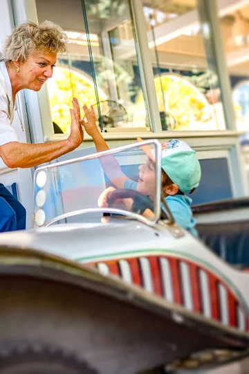 Creating memories An employee at an attraction gives a little boy a high five.